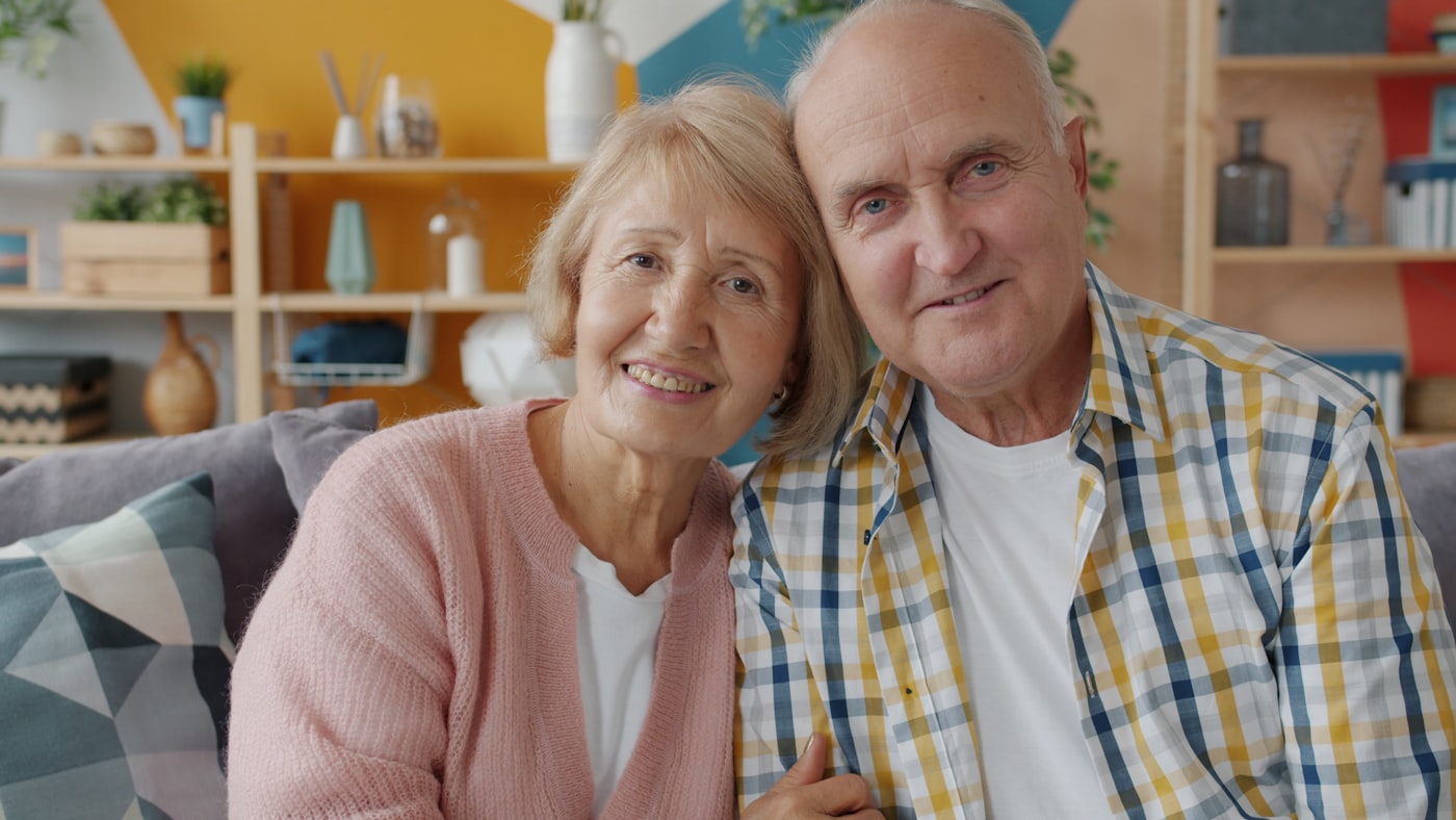 An older couple together at home, supported and at peace.